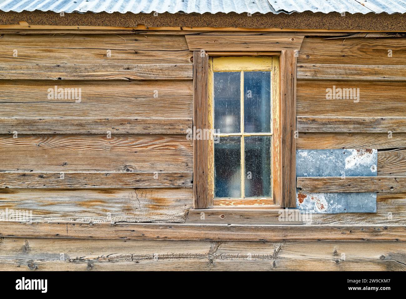 The window in the exterior wall of a vintage wood building with a