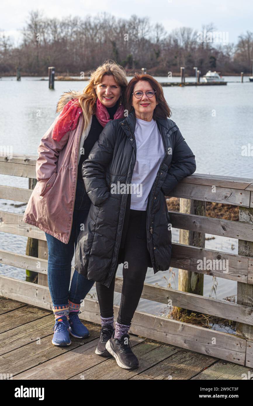 Mother and adult daughter on a wooden jetty in Richmond British Columbia Canada Stock Photo