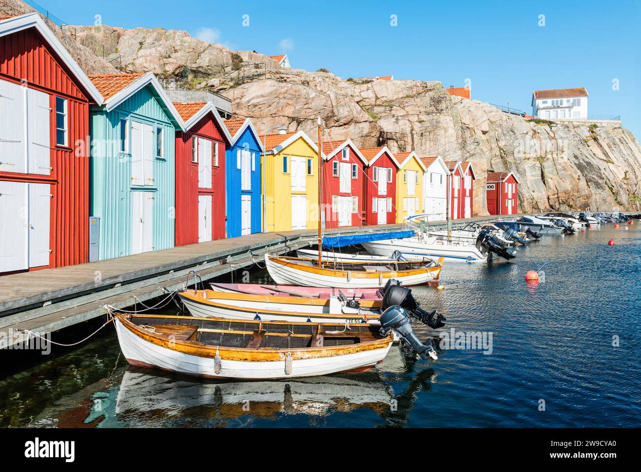 Boat sheds and warehouses with red wooden facades between granite rocks ...