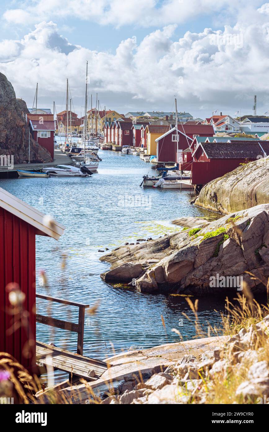 Boat sheds and warehouses with red wooden facades and granite rocks in the harbour of Smögen in the archipelago of the Swedish west coast Stock Photo