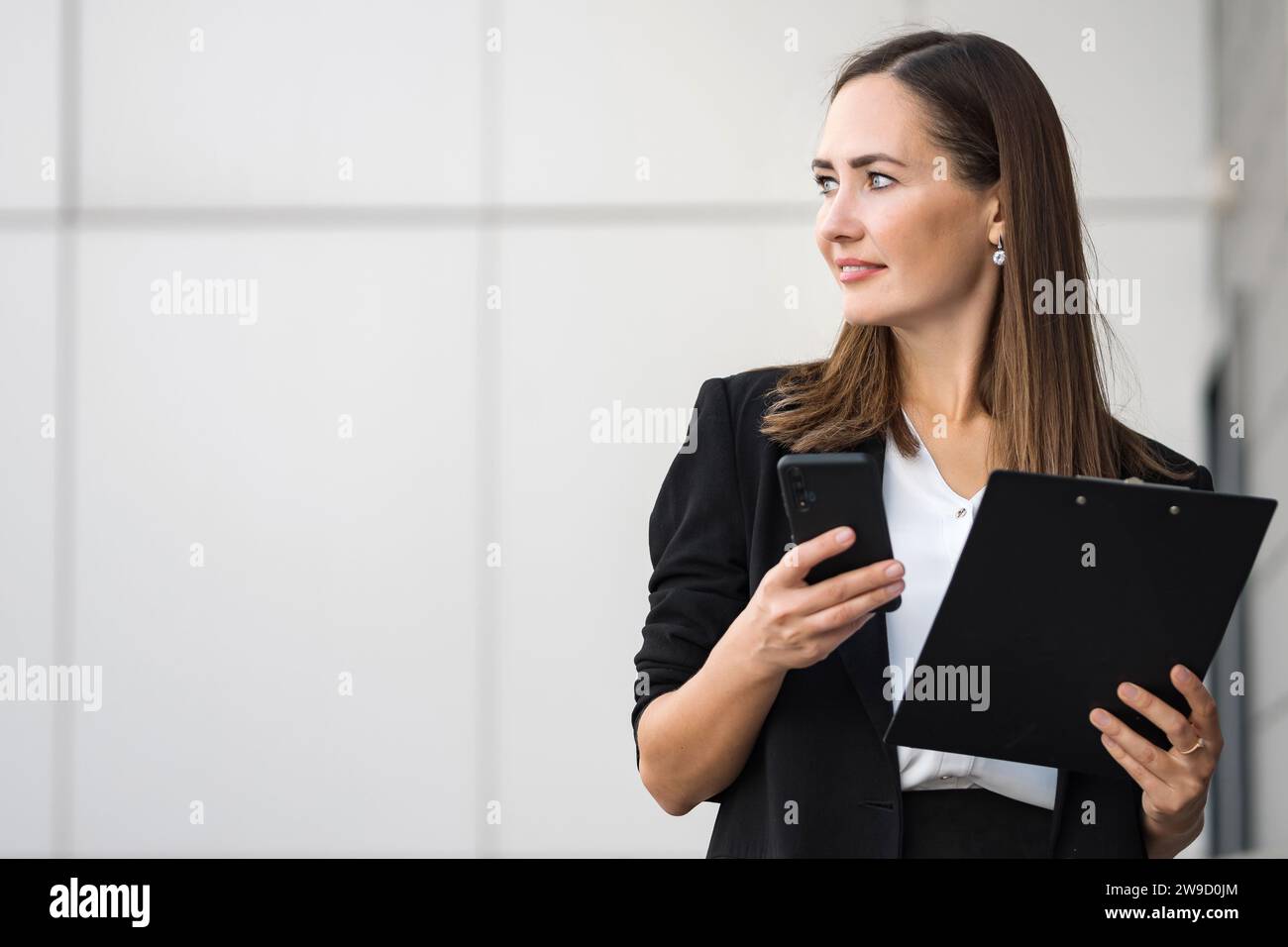 Female office worker just finished phone conversation by office Stock Photo