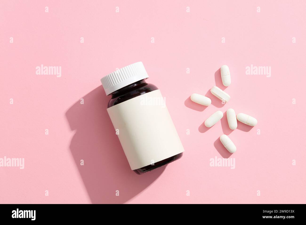 An unlabeled medicine bottle, by several white pills on a
