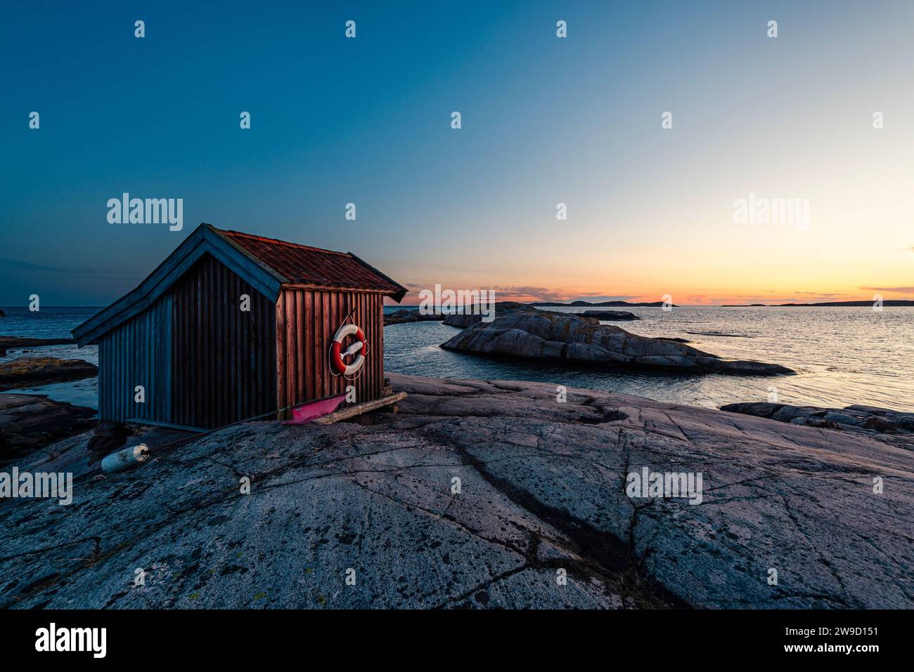 Wooden hut in the glowing twilight at dusk on the rocks in the Tjurpannan nature reserve in the archipelago of the Swedish west coast Stock Photo