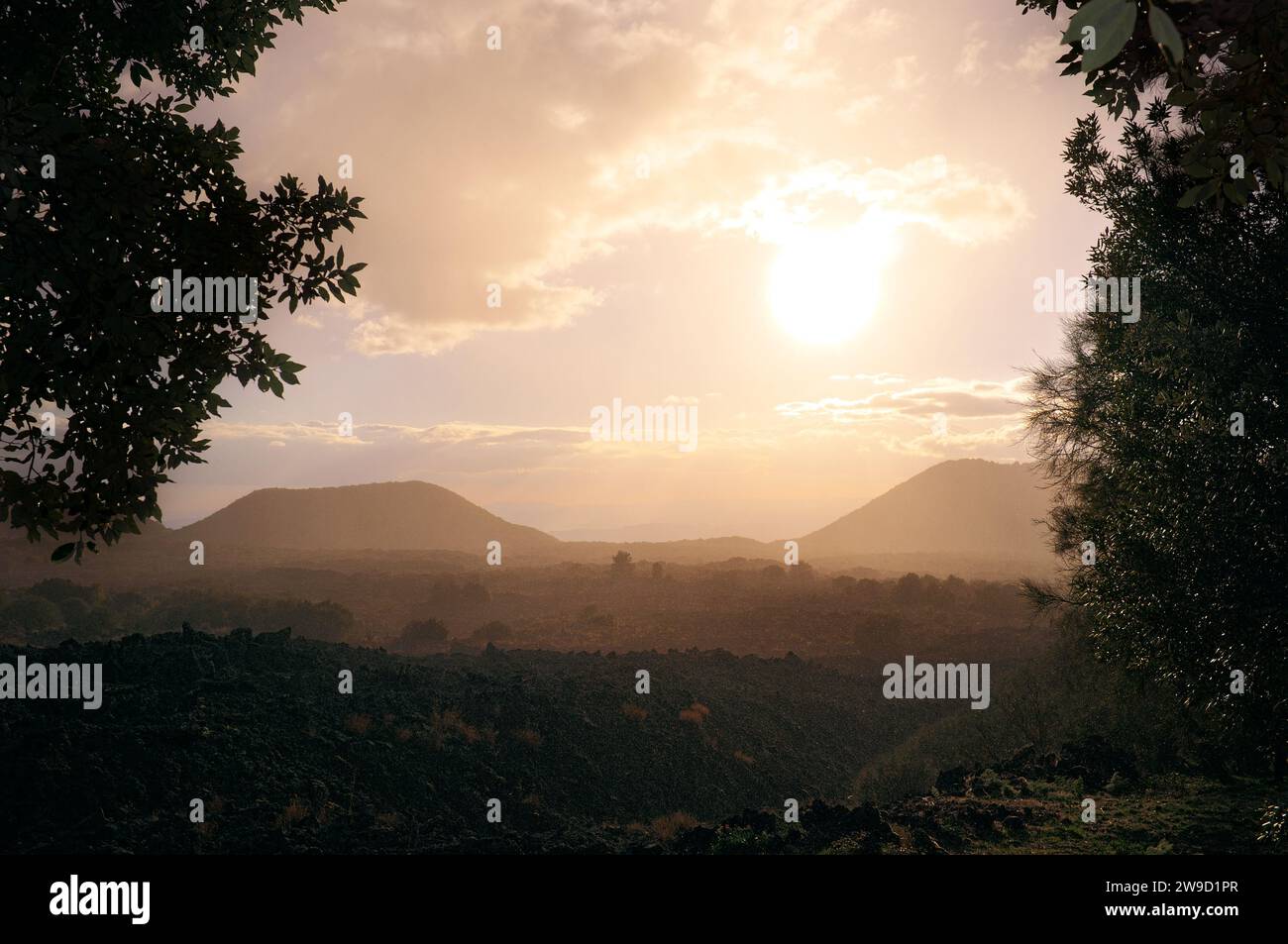 raining in sunlight on landscape of old and wide lava field and inactive old volcanoes in Etna Park, Sicily, Italy Stock Photo