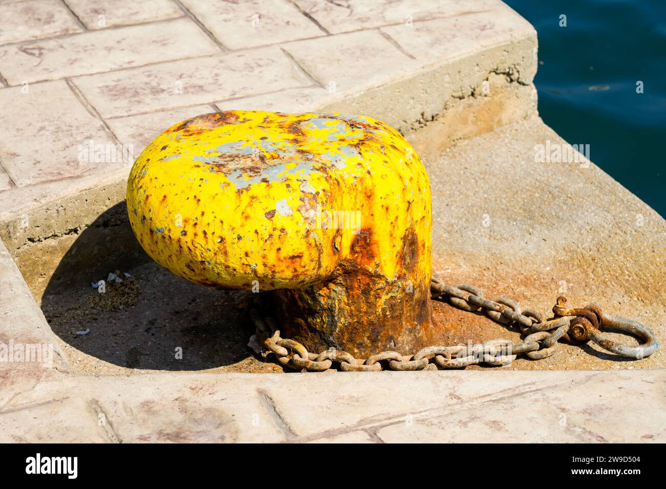 Old rusty bollard at the harbor. Stock Photo