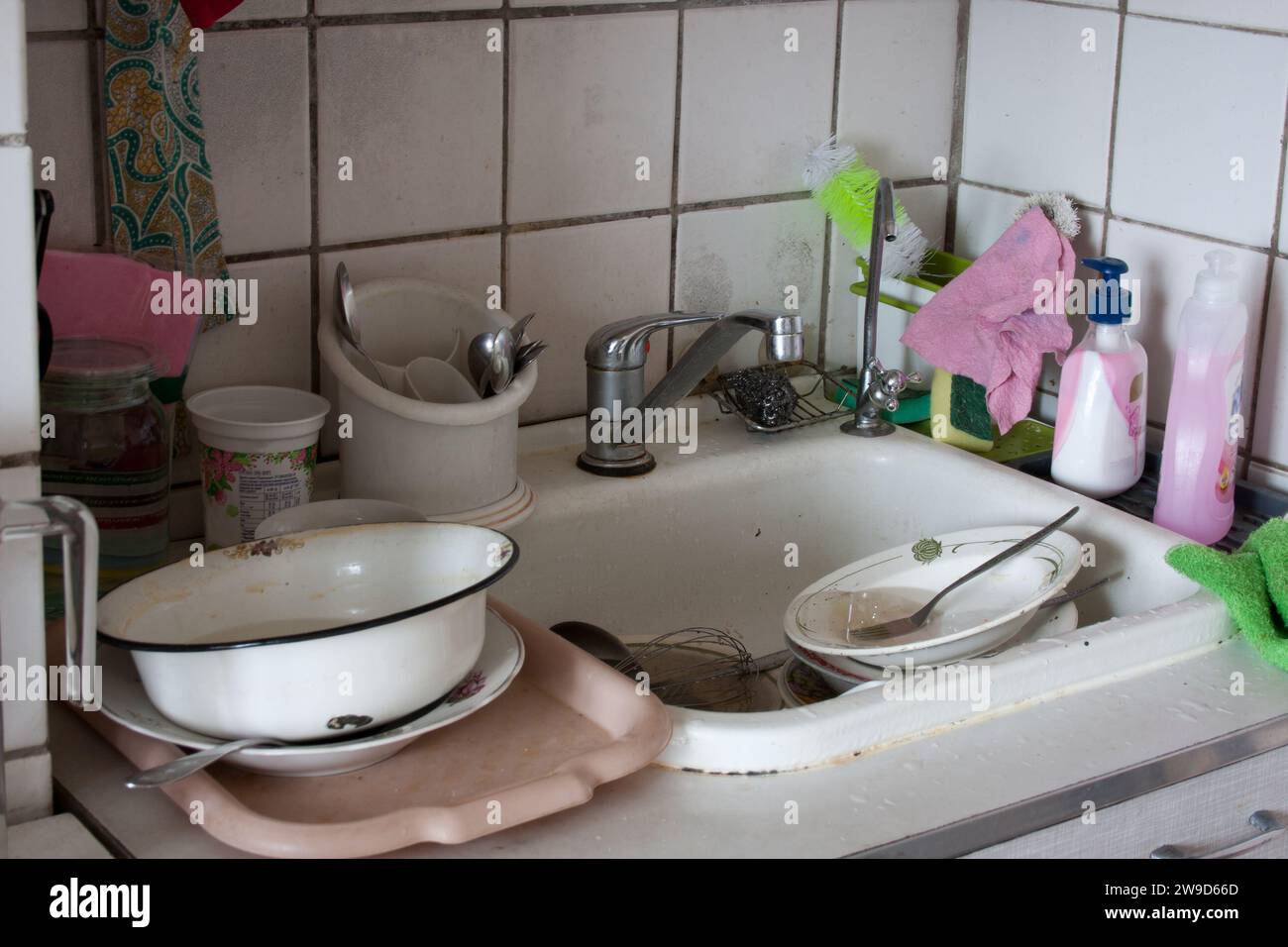 Dirty dishes in sink waiting to be washed. Dirty sink in apartment kitchen. Unsanitary ...