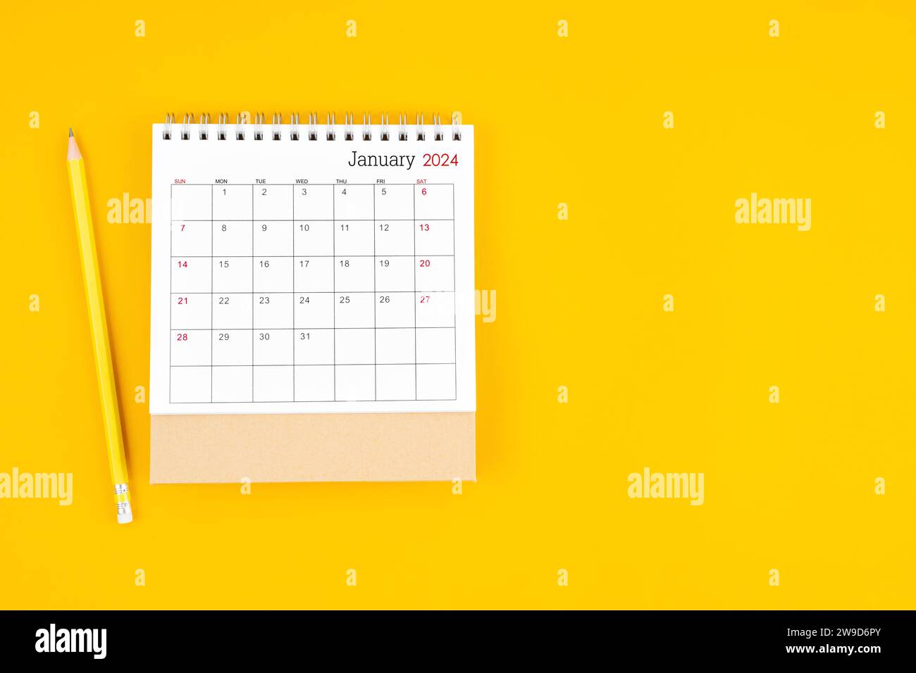 January 2024 desk calendar and wooden pencil on yellow color background ...