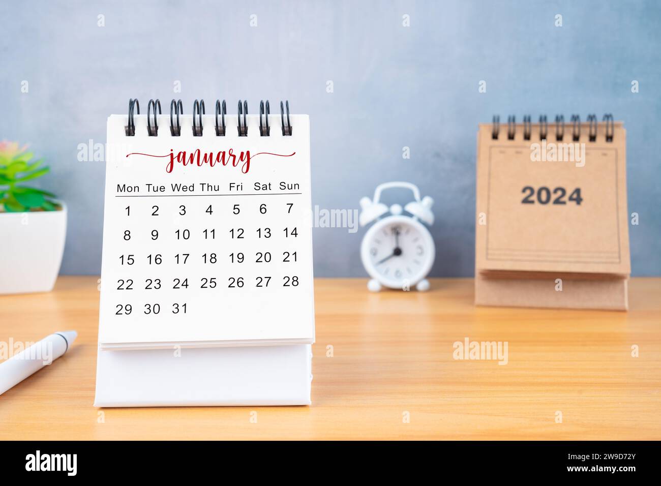 Front view of January desk calendar for 2024 year and alarm clock with ...