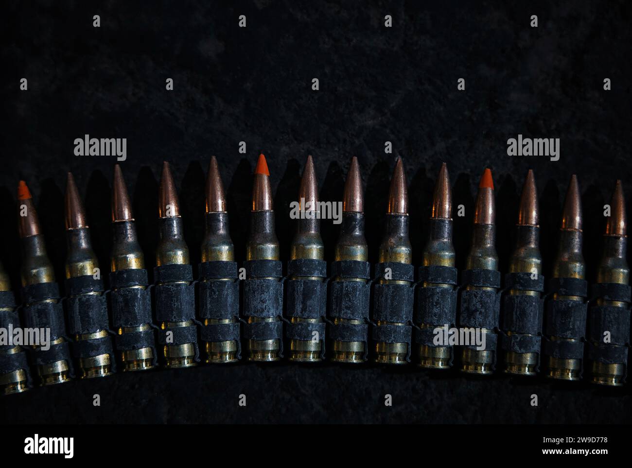 Machine gun bullet belt on the floor. Background on the military theme. Ammo, chain of ammo on concrete background. Top view of machine gun belt Stock Photo