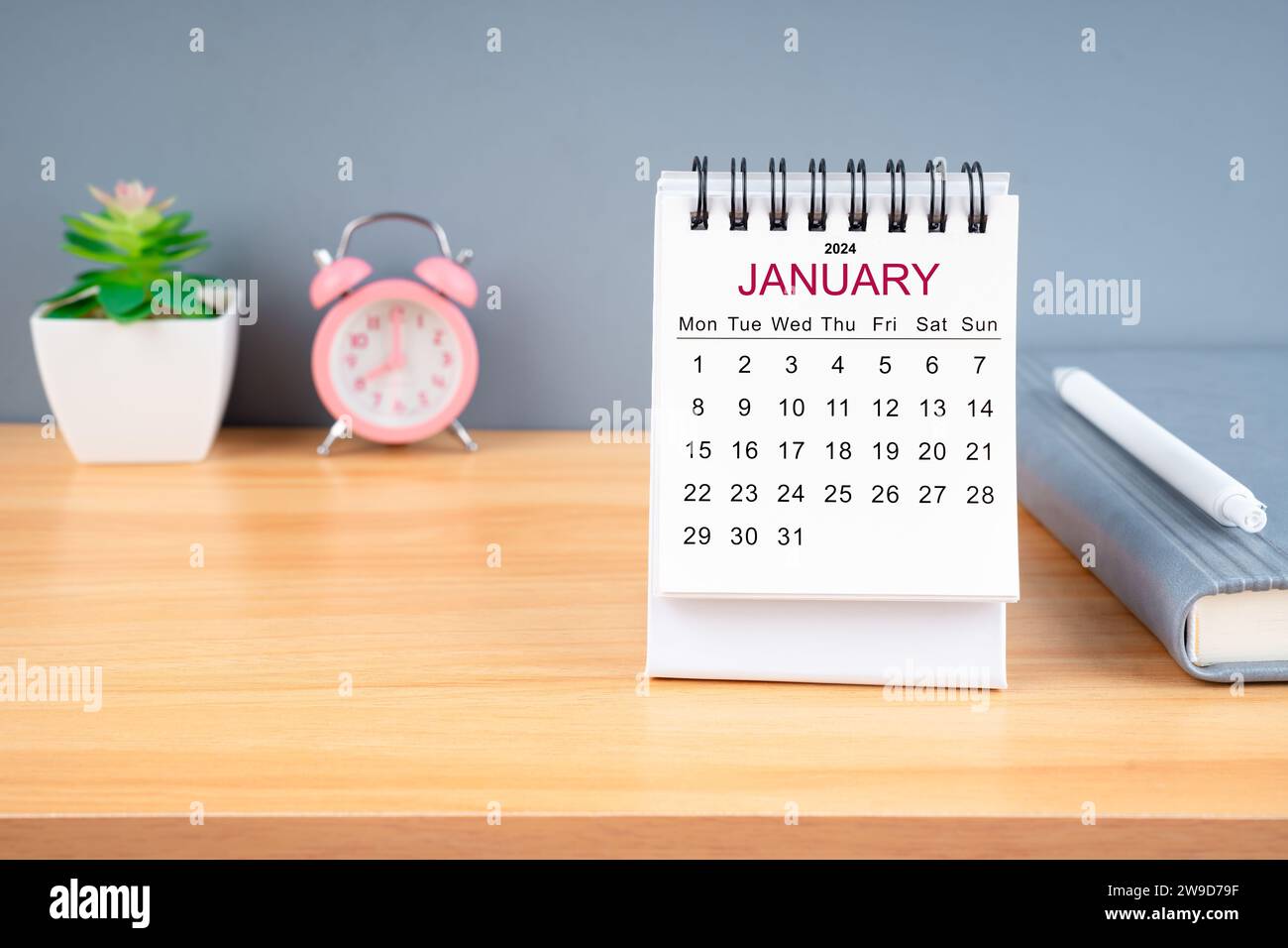 January Monthly desk calendar for 2024 year and alarm clock on wooden ...