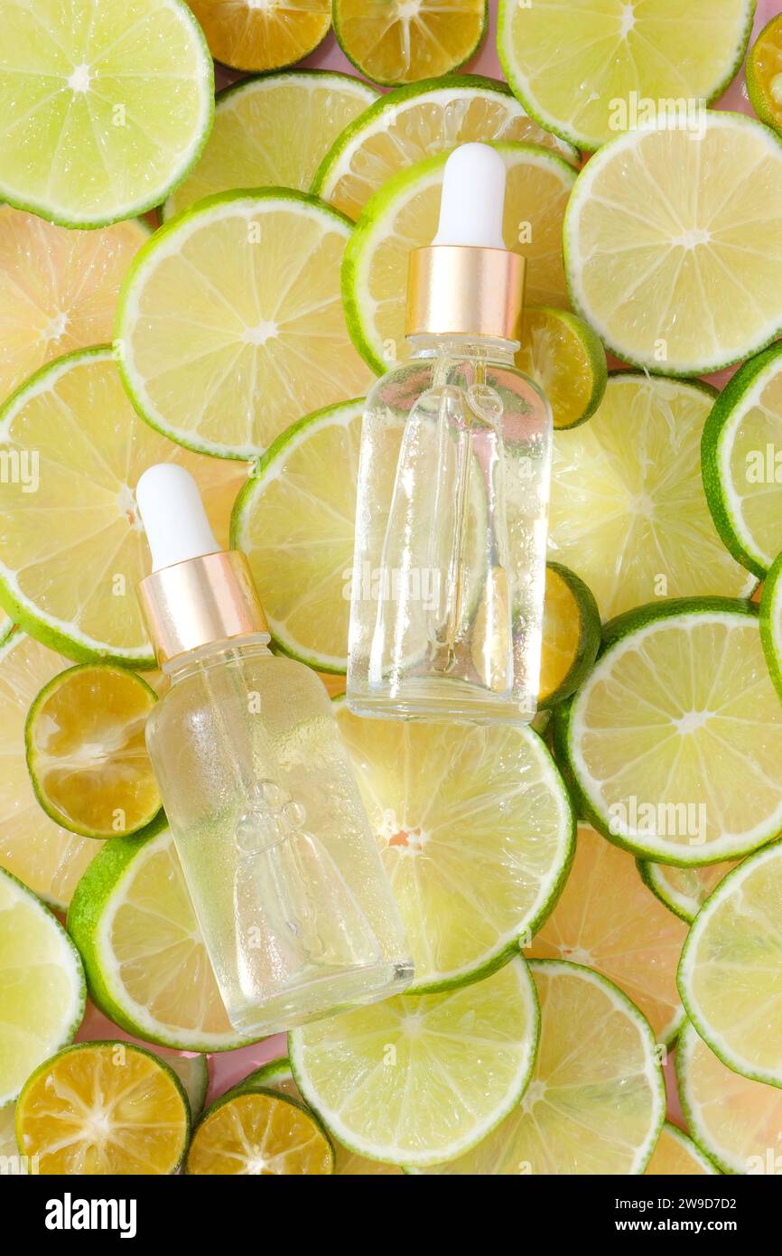 Top view of two unlabeled serum bottles placed on top of line and kumquat slices. Creative scenes for product advertising. Dropper bottles without lab Stock Photo