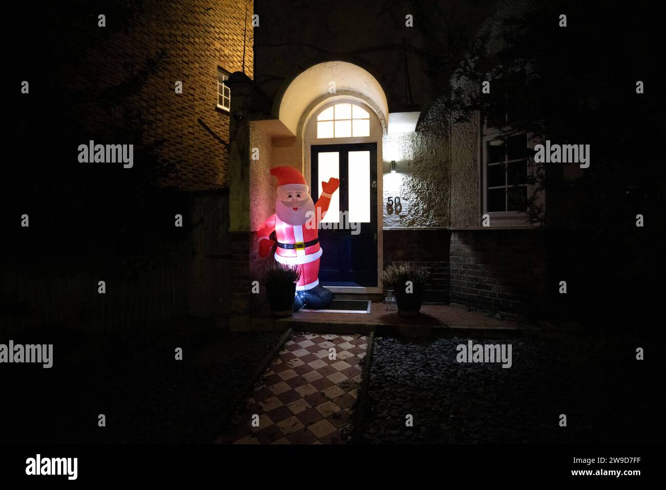 Residential house with inflatable Santa Clause ill united at the front doorway, London, England, United Kingdom Stock Photo