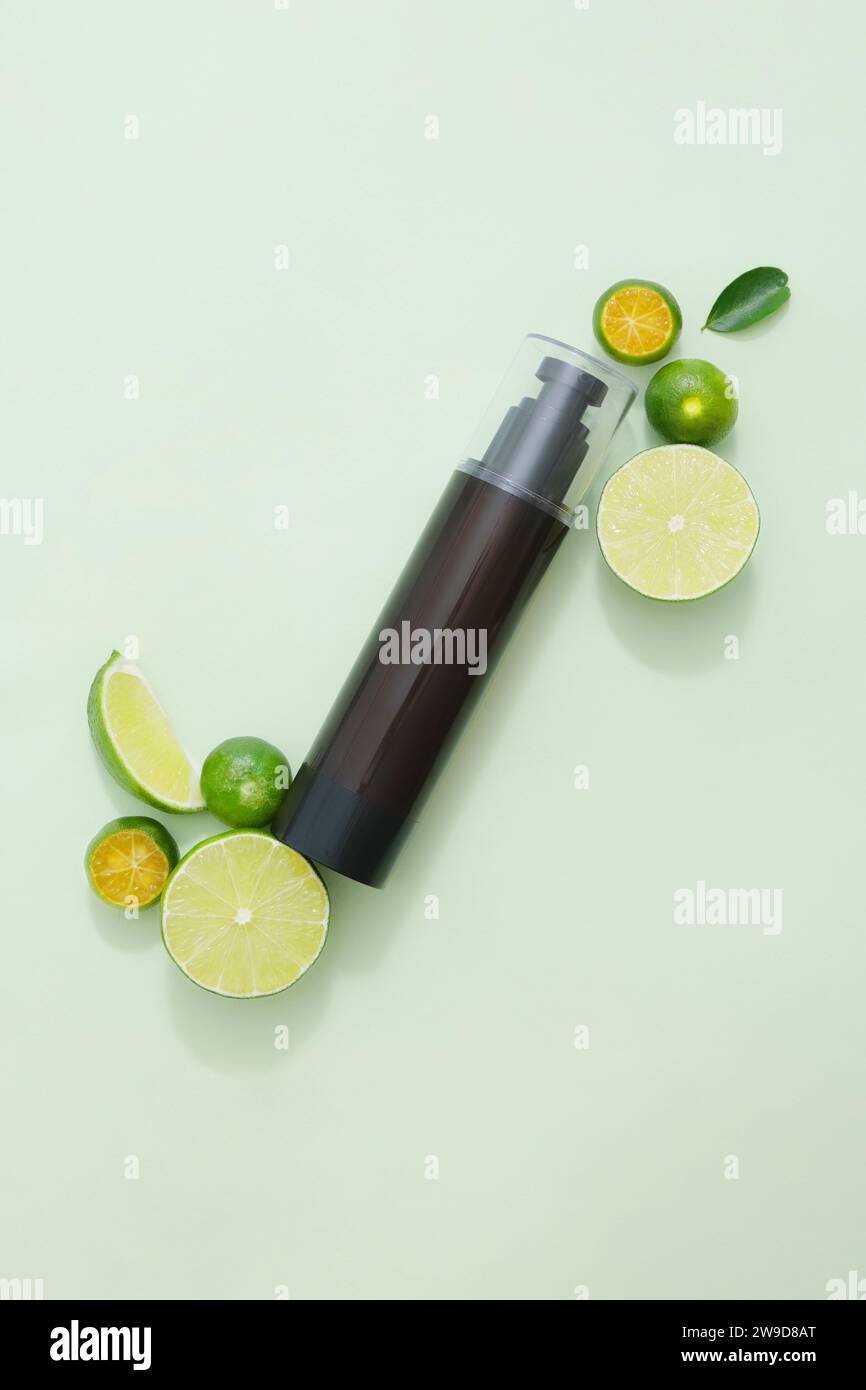 Mockup scene for advertising product with natural ingredient rich in vitamin C - kumquat and lime. An amber bottle unbranded for design packaging. Top Stock Photo