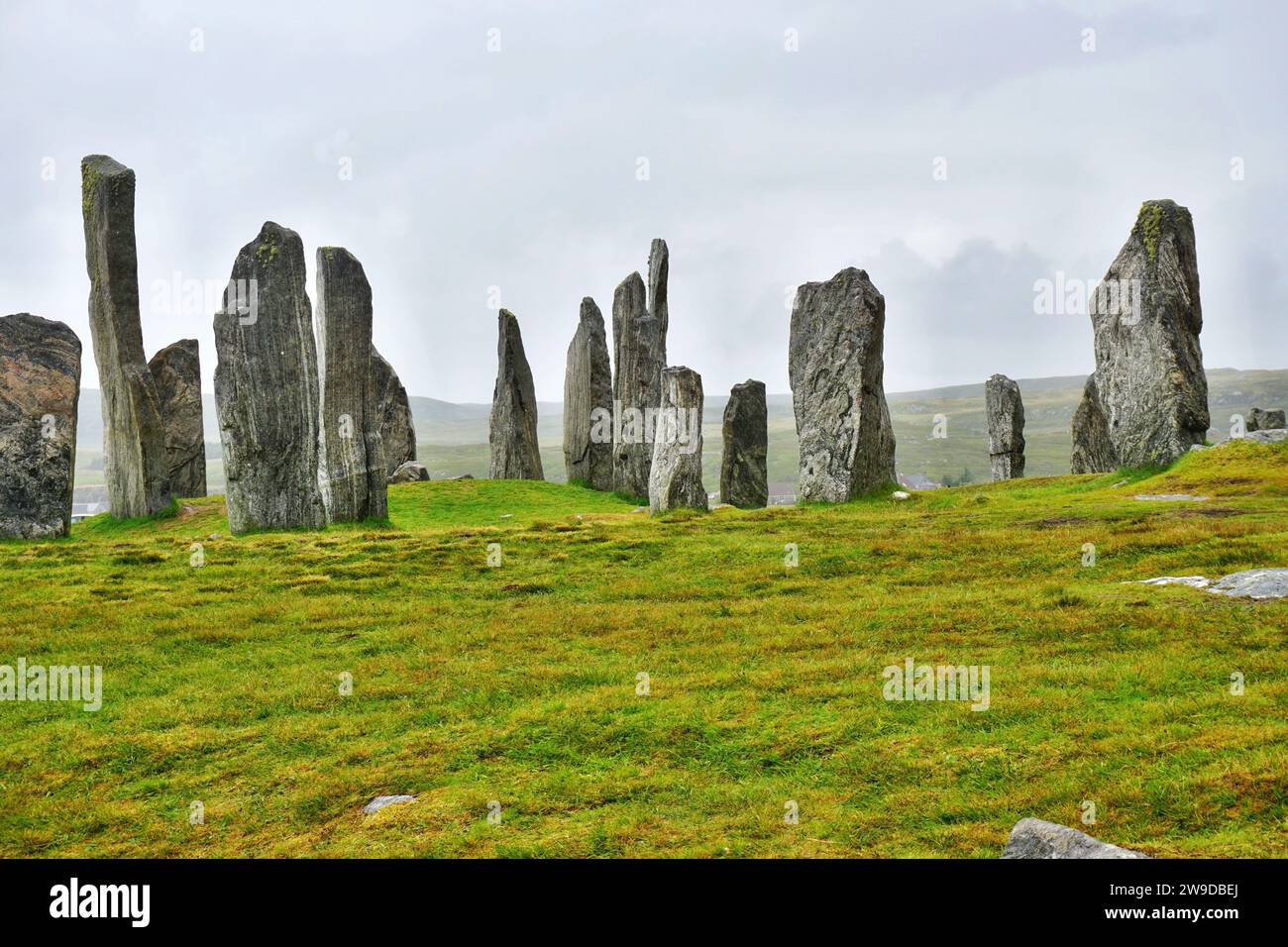 Callanish Standing Stones form a dark silhouette against an overcast gray sky on Lewis Island, Scotland. The Neolithic arrangement is quite mysterious Stock Photo