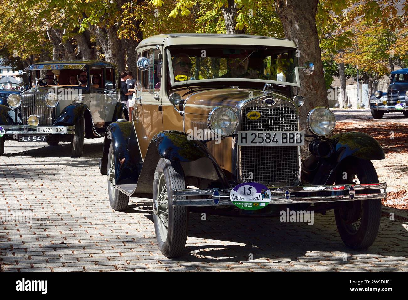 A Ford and a Rolls Royce classic cars on the road in a car festival in San Lorenzo de El Escorial, Madrid. Stock Photo
