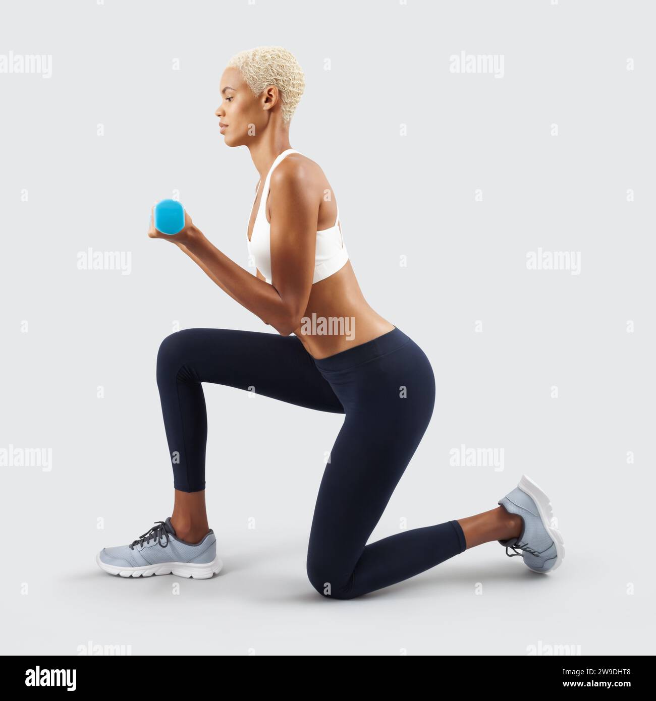 Latin American woman lifts dumbbells, young female athlete doing