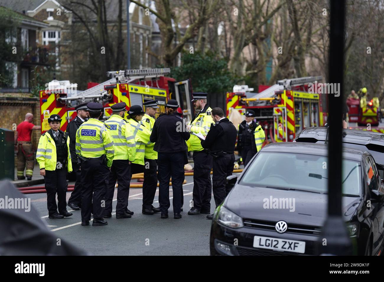 Fire engines and police officers on Seagrave Road in Fulham, west London, as firefighters tackle a blaze at London Oratory School. An atrium is alight in the four storey building, the fire brigade said. Picture date: Wednesday December 27, 2023. Stock Photo