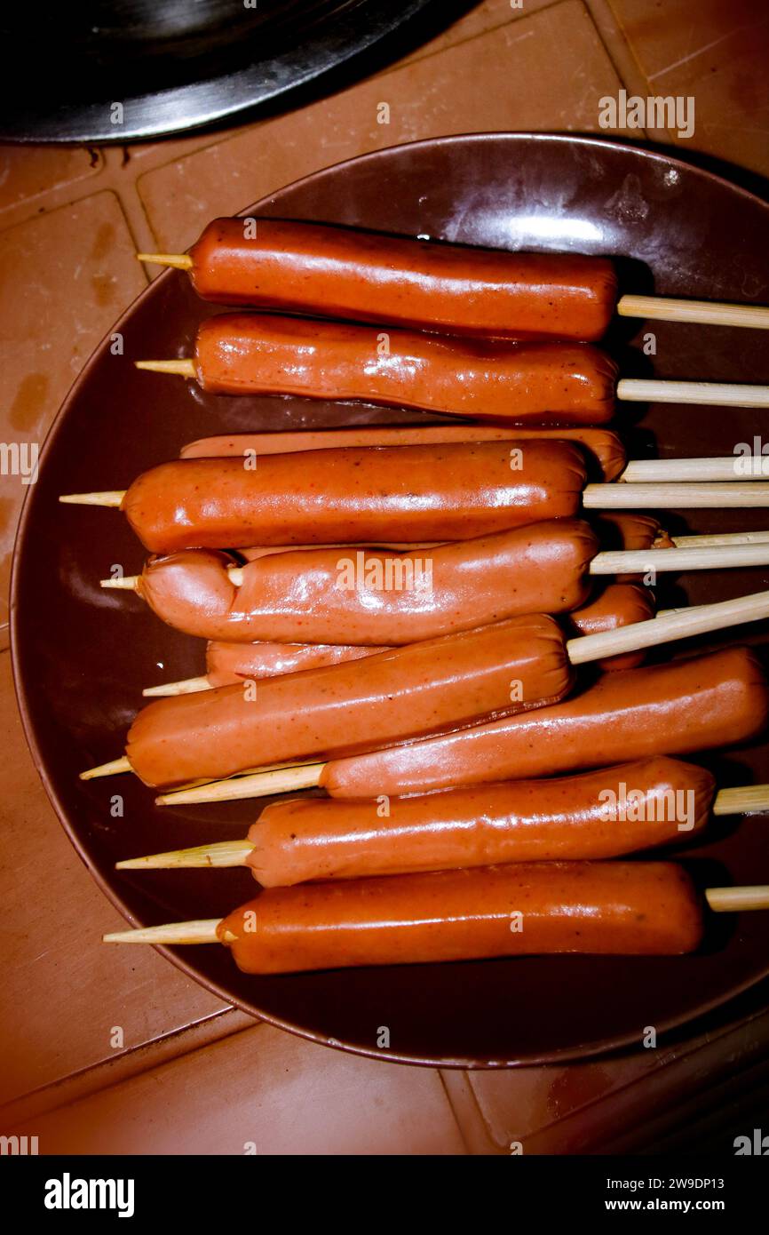 Collection of raw sausages to be grilled, grilled sausages on a food stand. stick sausages Stock Photo