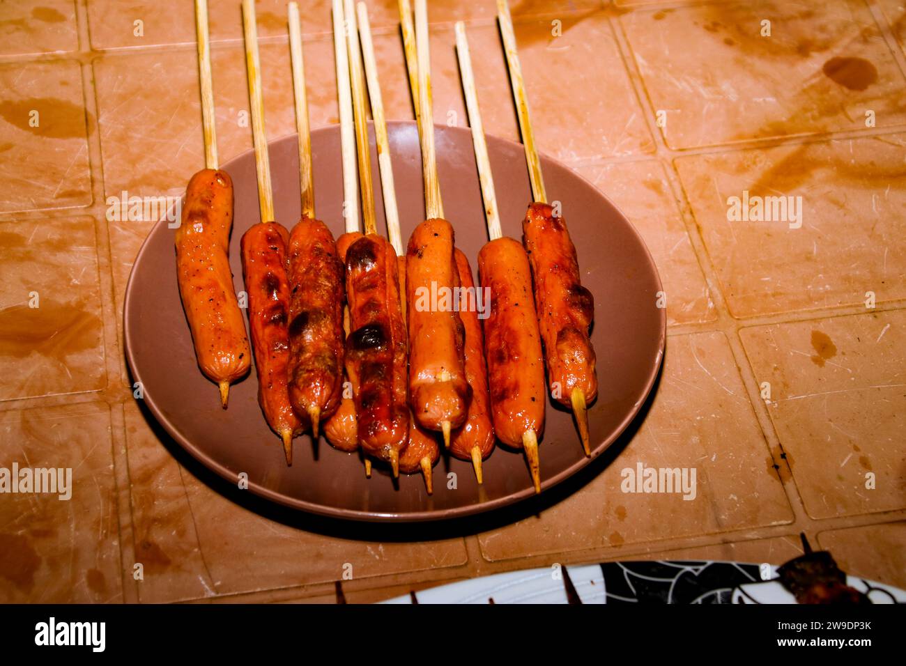 Collection of raw sausages to be grilled, grilled sausages on a food stand. stick sausages Stock Photo