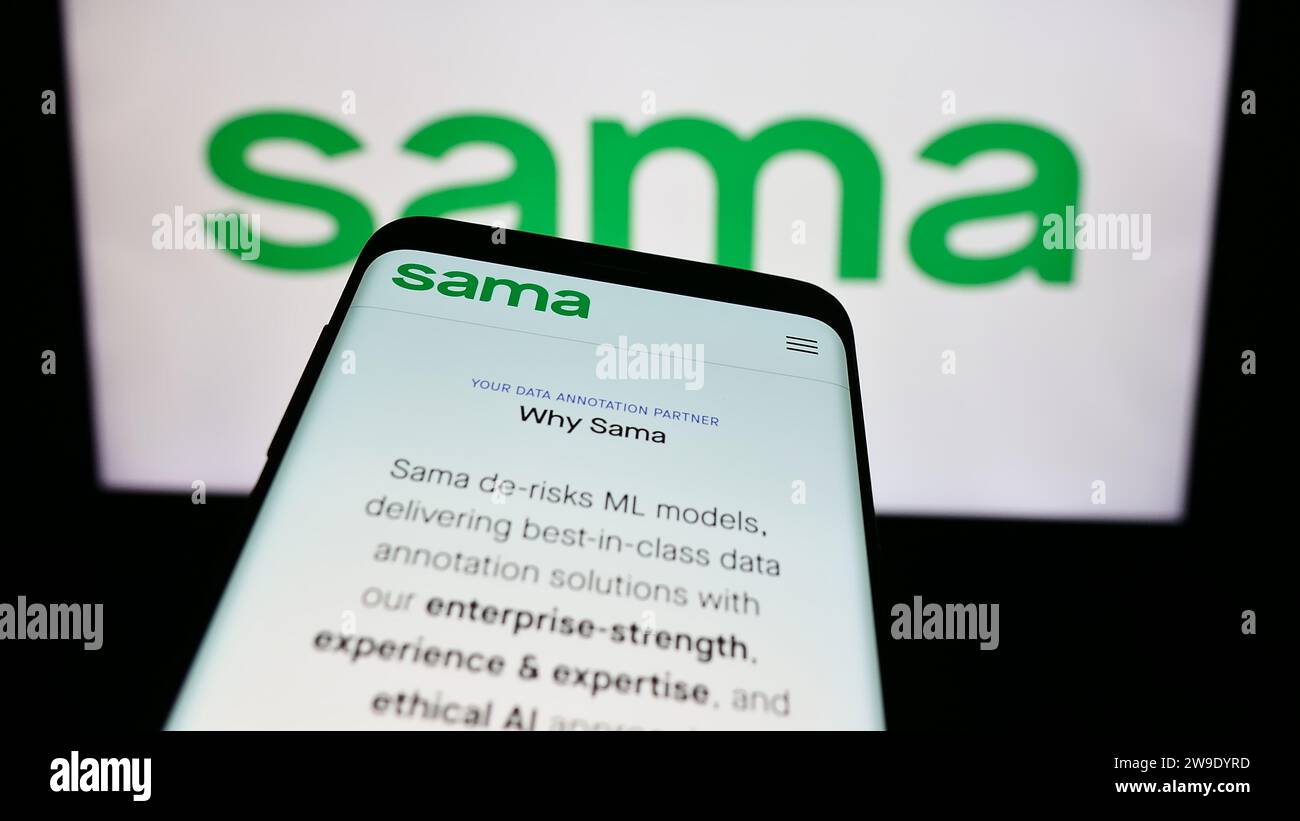 Mobile phone with website of US company Samasource Impact Sourcing Inc. (Sama) in front of business logo. Focus on top-left of phone display. Stock Photo