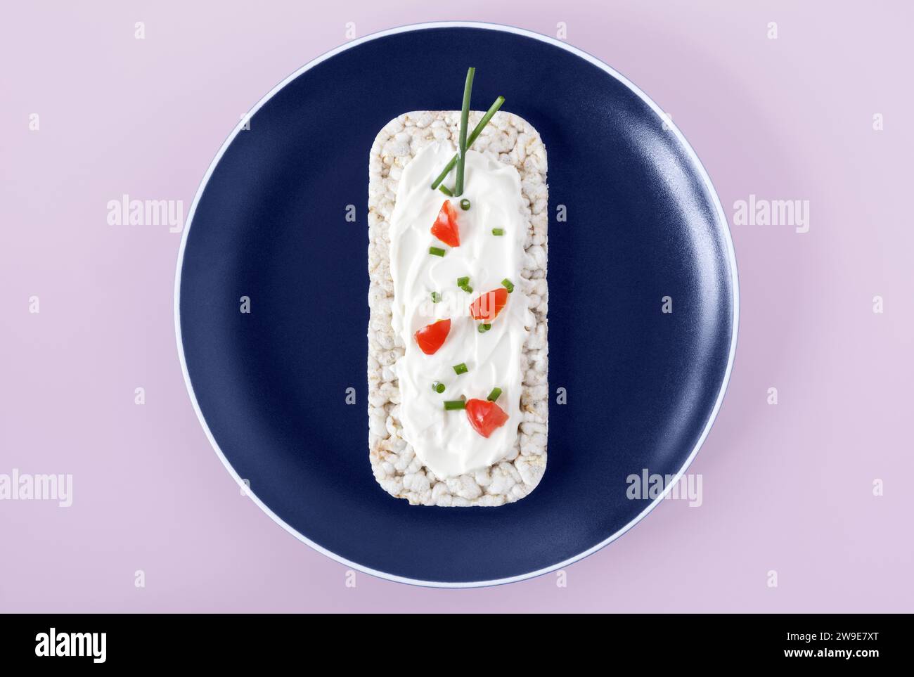 Rice cake topped with soft cheese, tomatoes and chives Stock Photo - Alamy