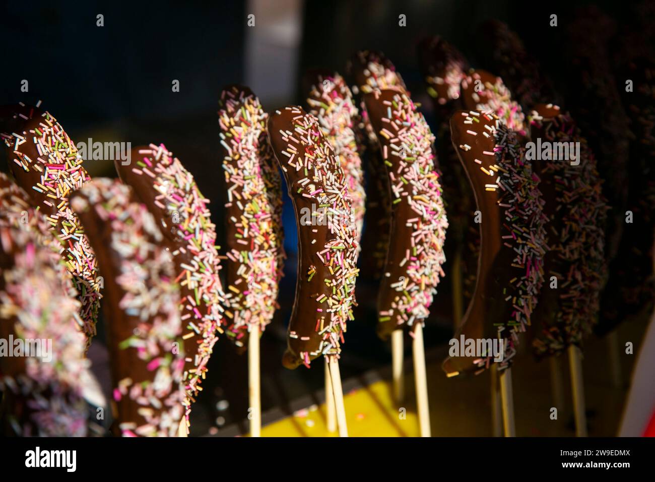 Bananas dipped in chocolate with colored candy shavings. Stock Photo