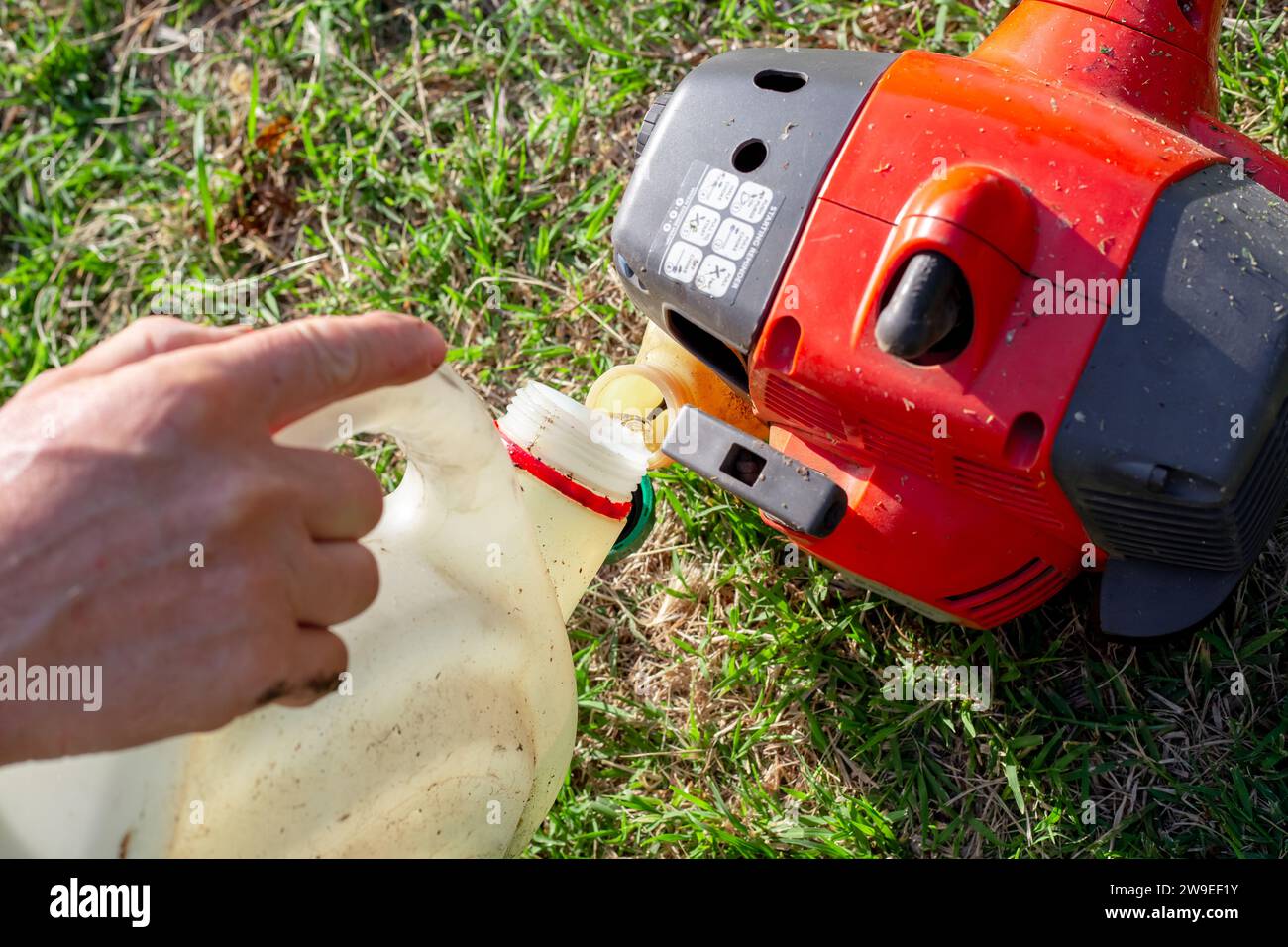 A gardener fills a lawn mower with - A Gardener Fills A Lawn Mower With A Mixture Of Gasoline And Oil Maintenance Of Garden Equipment 2W9EF1Y