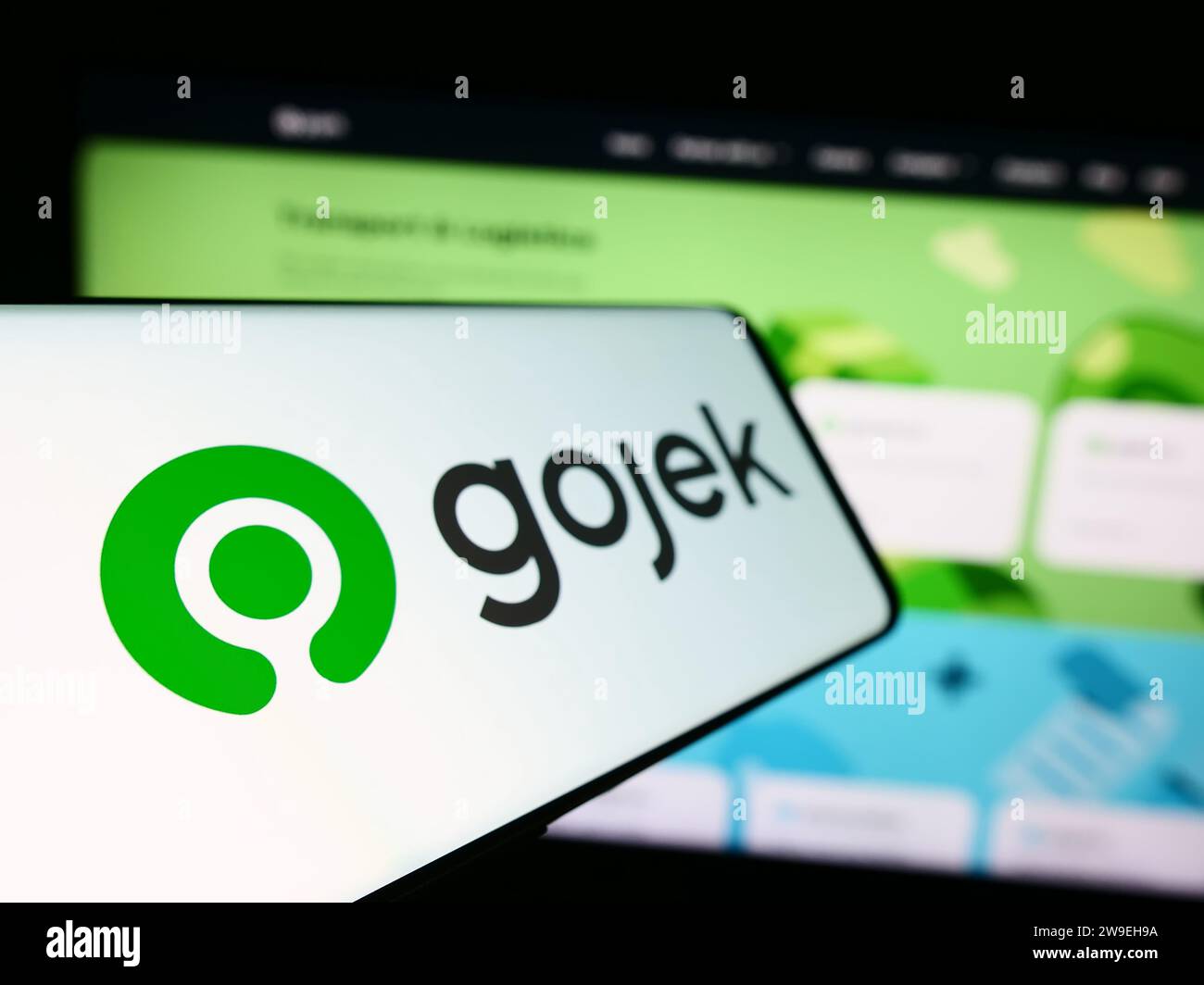 Mobile phone with logo of technology company PT Gojek Indonesia in front of business website. Focus on left of phone display. Stock Photo