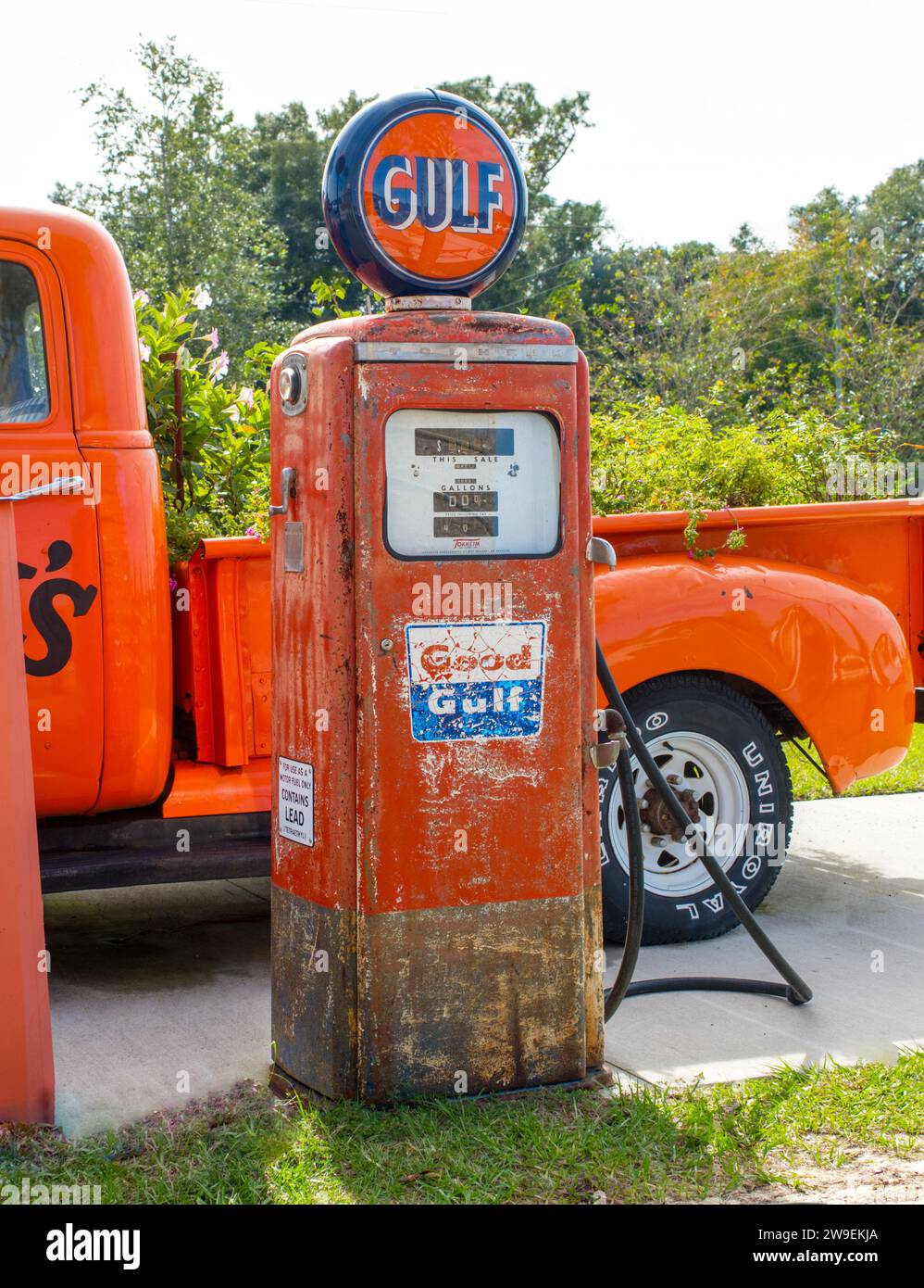 Ocala, Florida November, 2023 old orange gas pump by good gulf company brand logo next to old Chevy Chevrolet pickup truck with uniroyal rubber tires. Stock Photo
