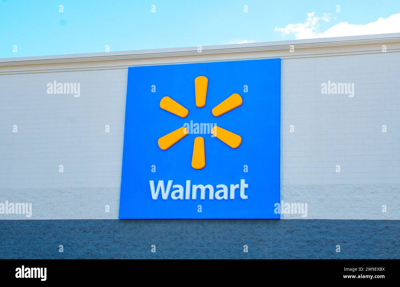 OCALA, FLORIDA USA - OCTOBER 22, 2023 World famous trademark Walmart sign and logo emblem.  Blue background with orange radiating dash, star or spark Stock Photo