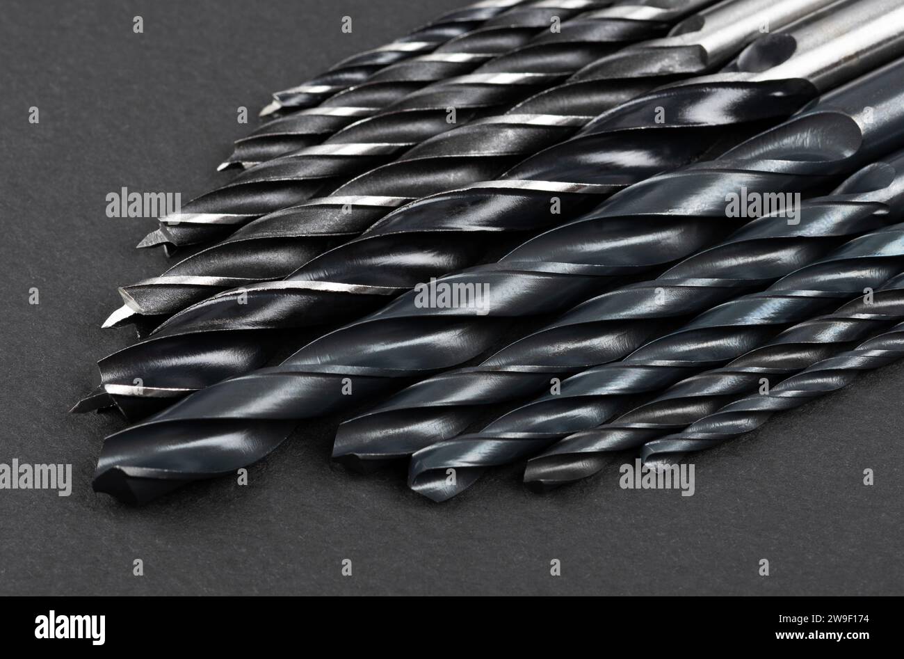 Set of different drill bits on dark background Stock Photo