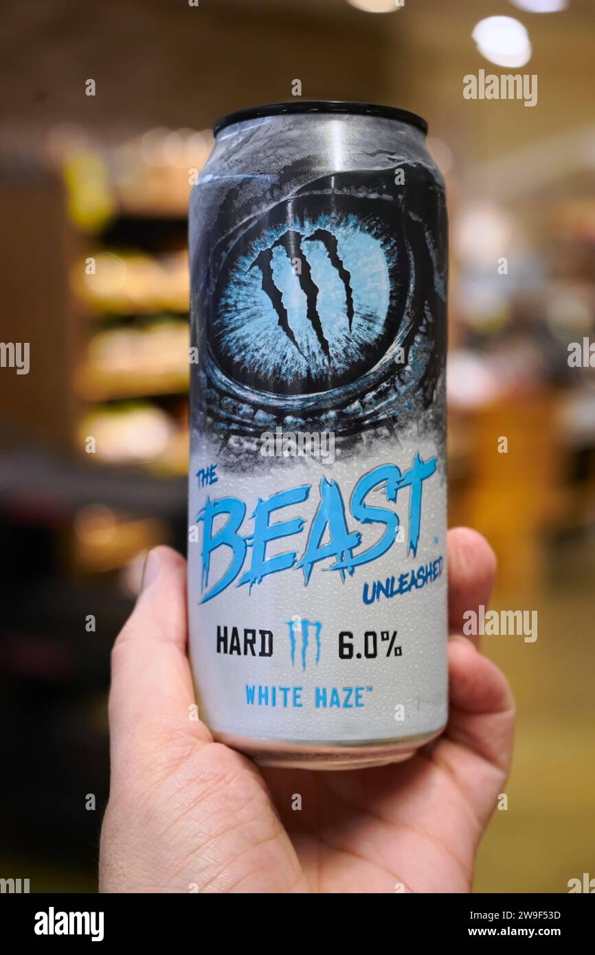 Honolulu, HI - December 24, 2023: Monster Beverage The Beast Unleashed White Haze flavor 6% alcohol hard seltzer energy drink can in hand at supermark Stock Photo