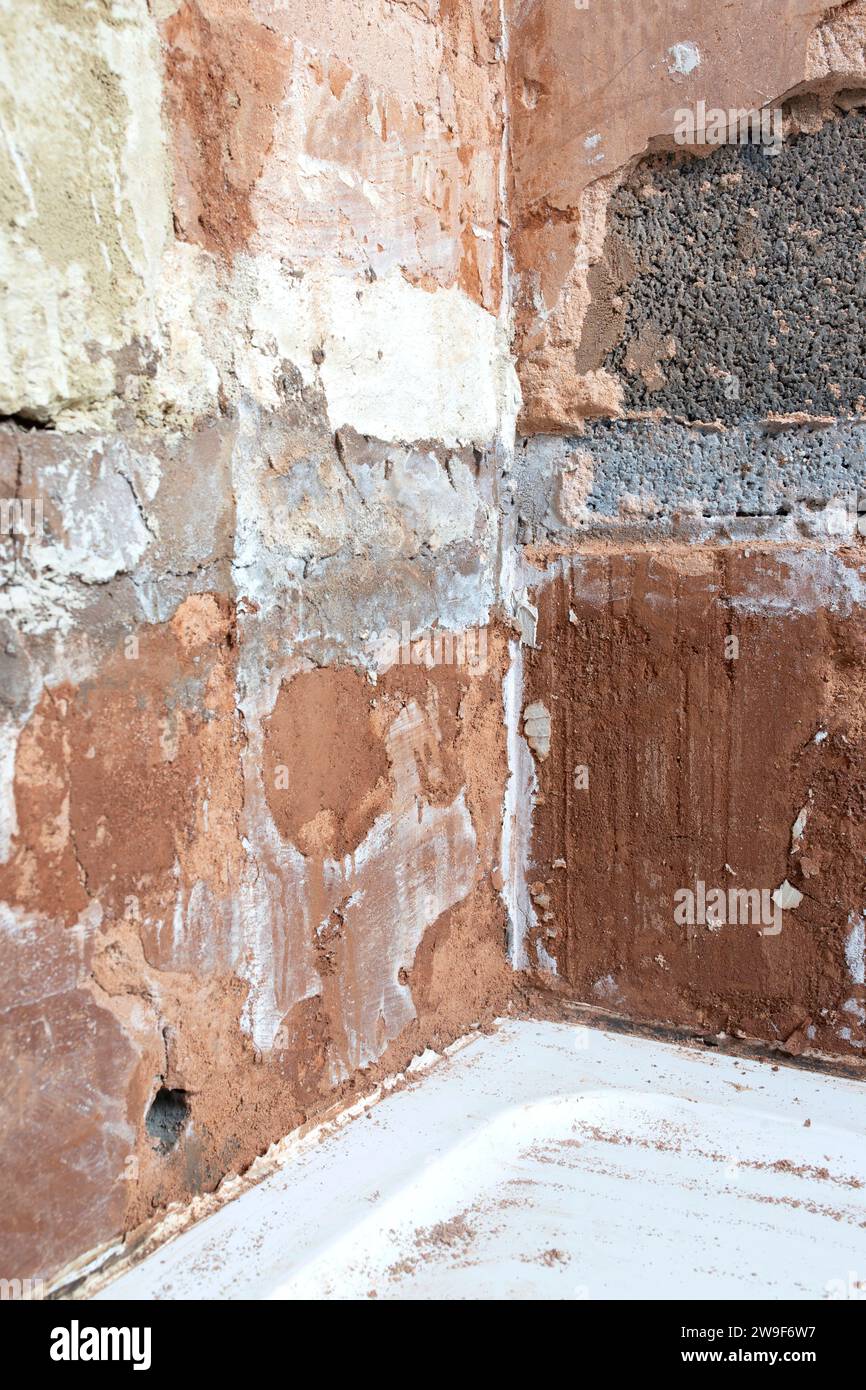 Damaged damp plaster exposing brick in a bathroom. Home improvement problems concept Stock Photo