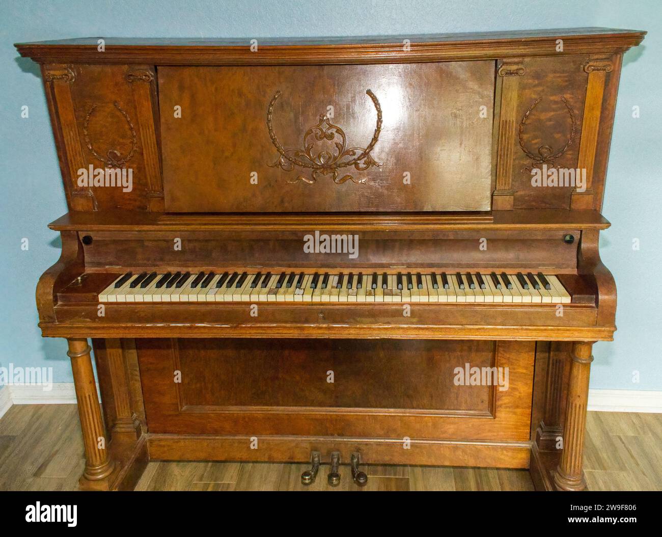 Old wooden upright grand piano black and white keys with detailed sconce Applique on late 1800s instrument, worn, broken, damaged and well played. Fro Stock Photo