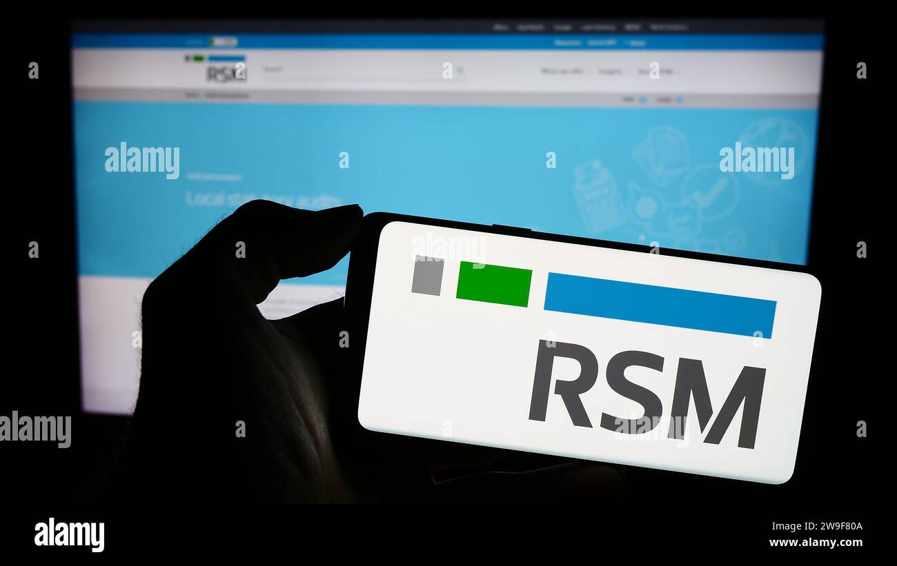 Person holding cellphone with logo of global accounting company RSM