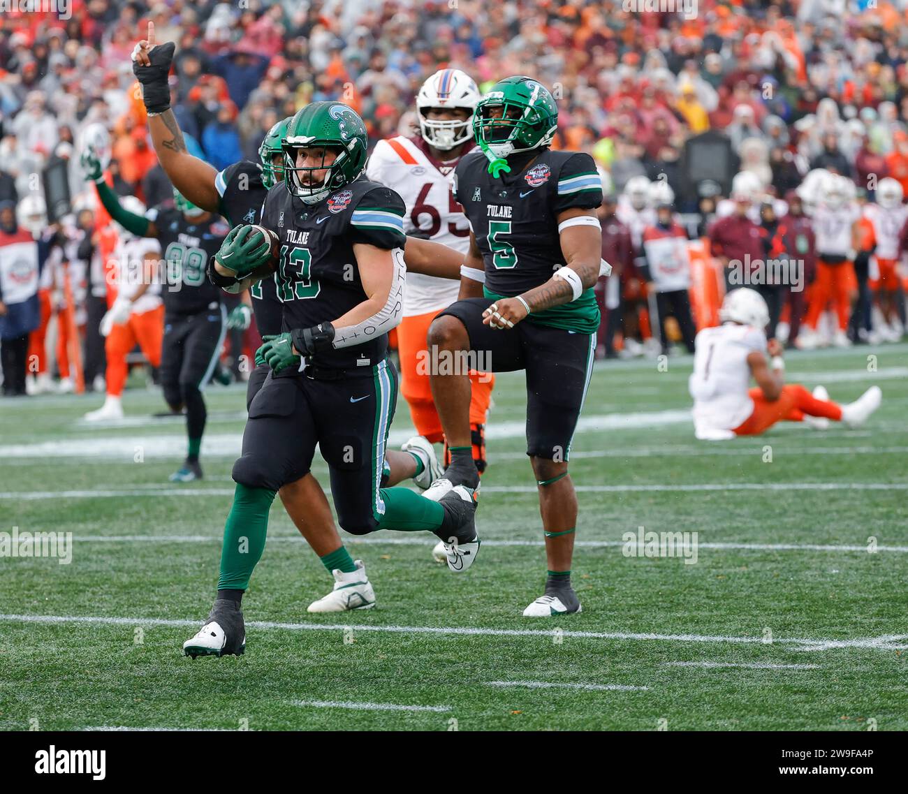 Annapolis, MD, USA. 27th Dec, 2023. Tulane Green Wave LB #13 Tyler Grubbs scoops up the football and runs for a touchdown during the Go Bowling Military Bowl between the Tulane Green Wave and the Virginia Tech Hokies at Navy-Marine Corp Memorial Stadium in Annapolis, MD. Justin Cooper/CSM/Alamy Live News Stock Photo