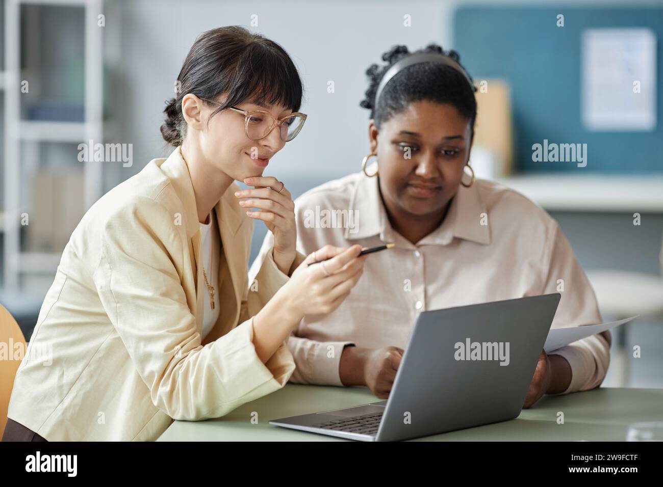 Two Female Colleagues Using Laptop Stock Photo
