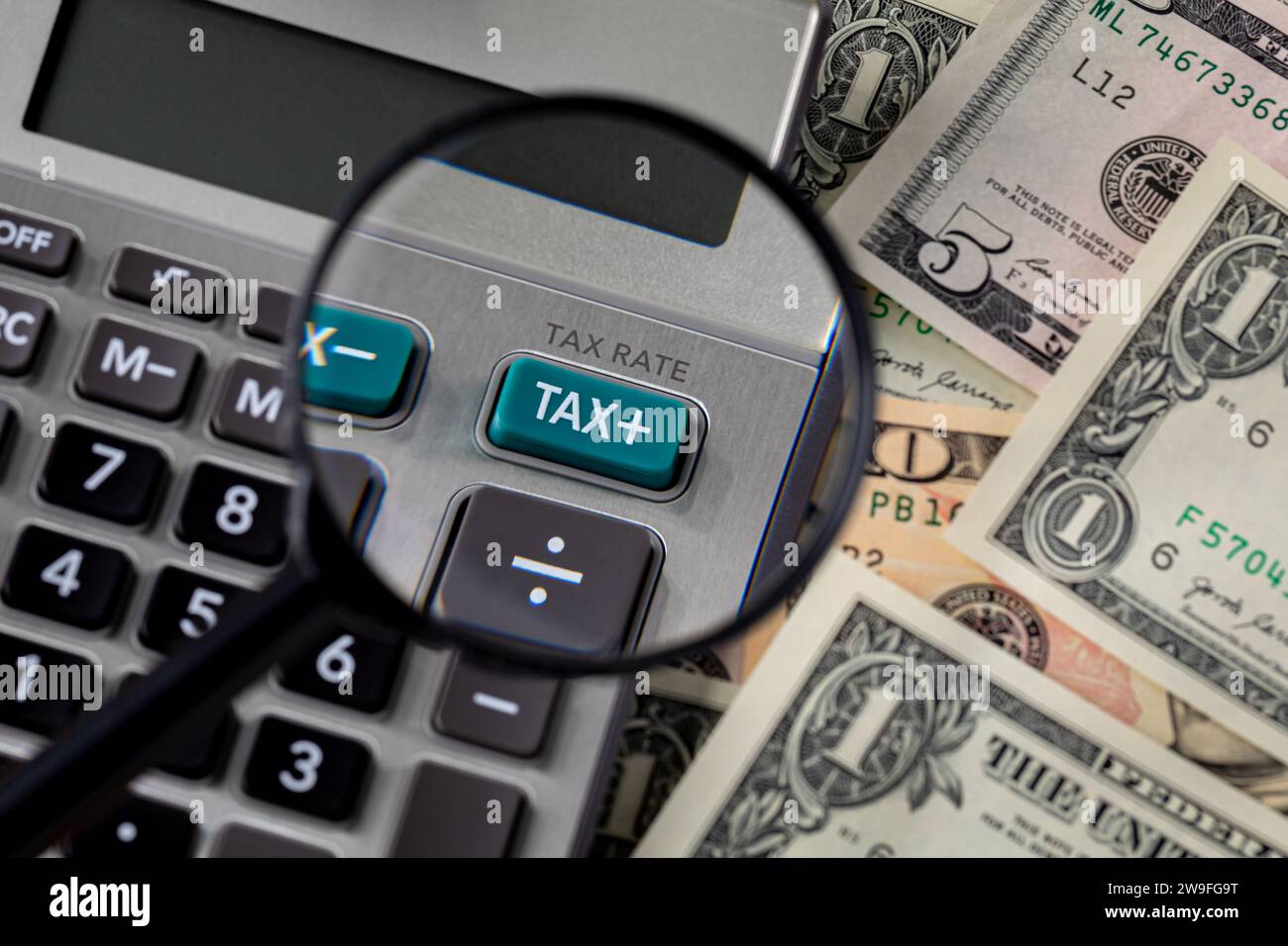 Tax calculator, magnifying glass and cash money. Income, sales and property taxes concept. Stock Photo