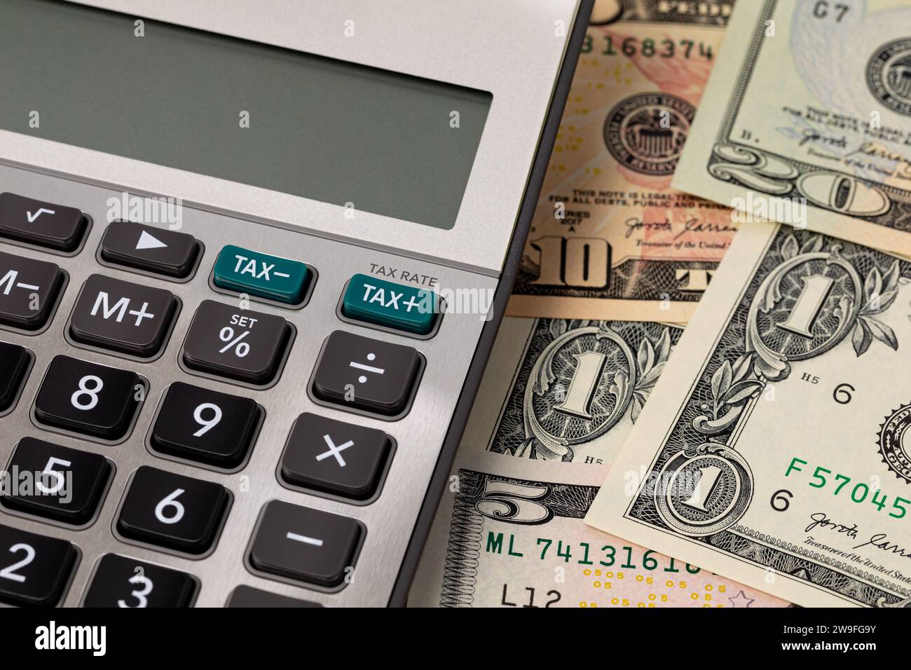 Tax calculator with cash money. Income, sales and property taxes concept. Stock Photo