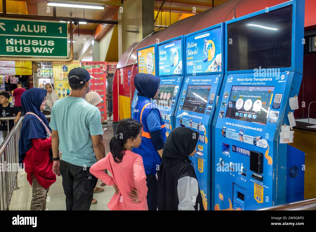 Jakarta, Indonesia - December 24, 2023: Unidentified people buying bus tickets from an electronic ticketing machine. Stock Photo