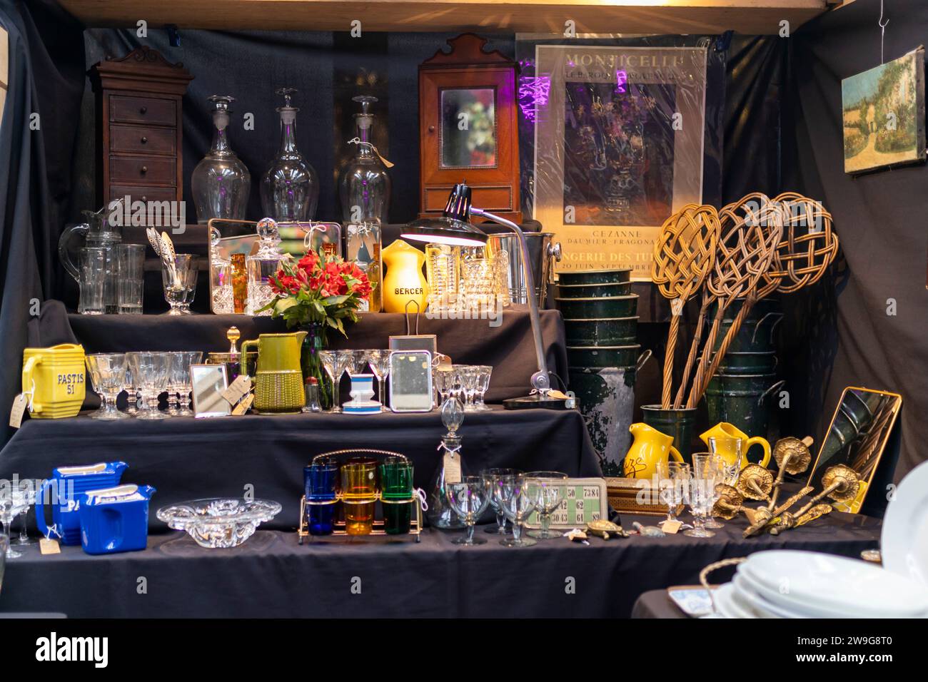LONDON UK -JUNE 27 2023: Spitalfields Antic Market. Display. Tennis rackets, crystal decanters, shot glasses, paintings, cups, kitchen utensils for sa Stock Photo