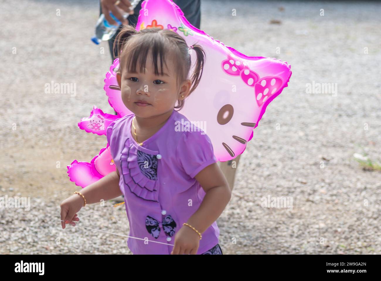 SURATTANI, THAILAND -NOV. 06, 2023: Young Burmese child is having fun at the Kathina merit-making festival of Burmese brothers and sisters living in T Stock Photo