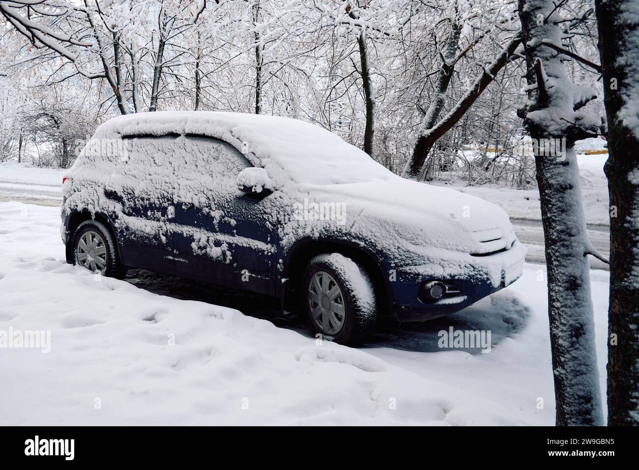 Ryazan, Russia - December 24, 2023: Car covered with snow on the road near a city park in winter Stock Photo