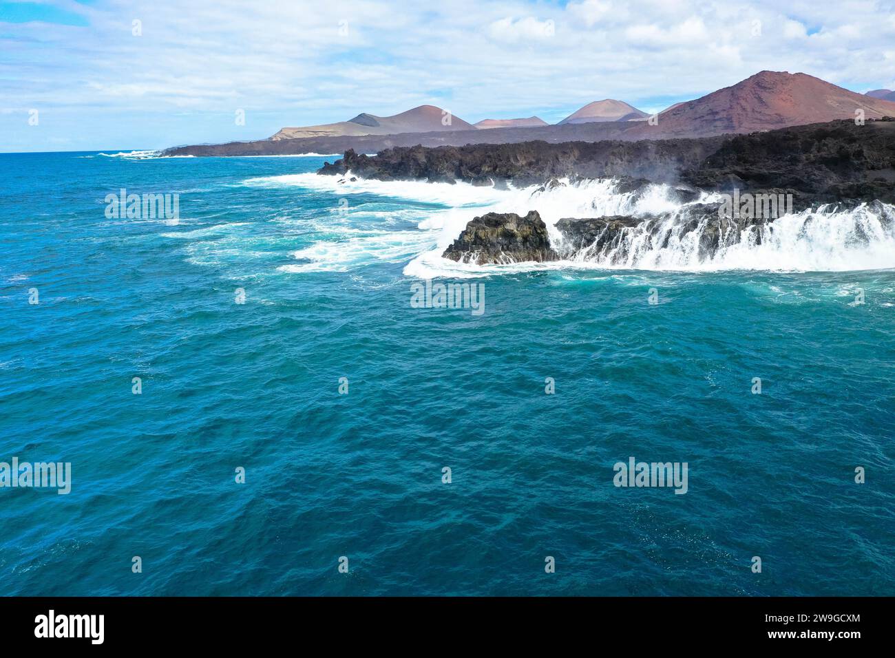 Aerial panorama view of Los Hervideros. Southwest coast, rugged volcanic coast, strong surf, sea caves, red lava hills. Lanzarote, Canary Islands, Spa Stock Photo