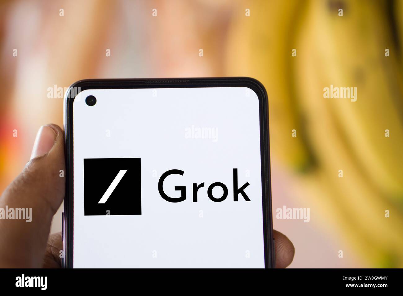 Dhaka, Bangladesh - 28 December 2023: Hand holding a phone with Grok AI chatbot. Stock Photo