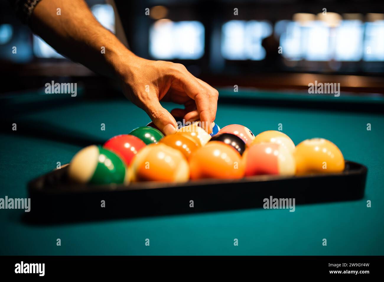 Pool player putting balls into the triangle Stock Photo