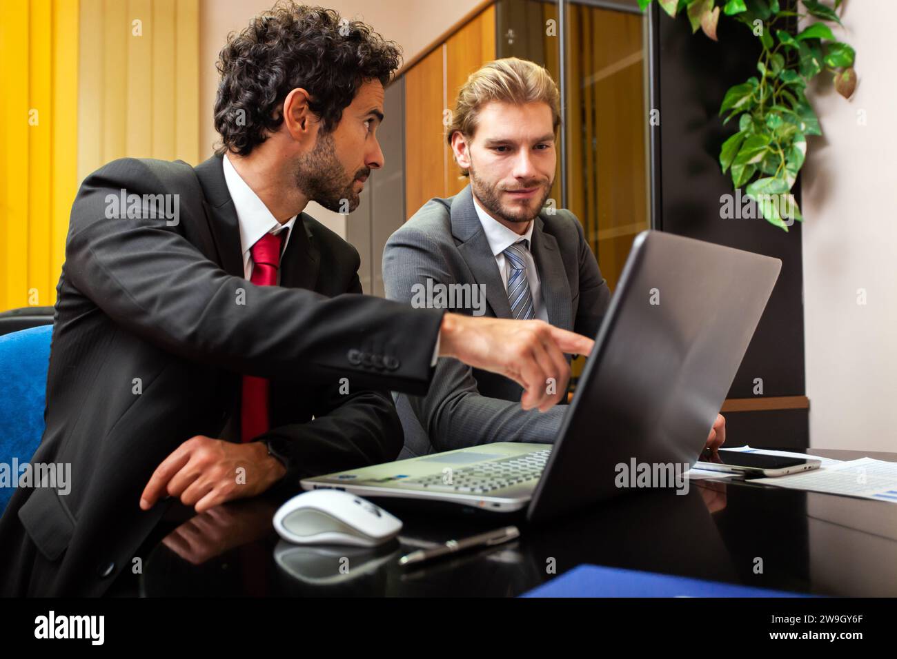 Two business partners working at a laptop in their office Stock Photo