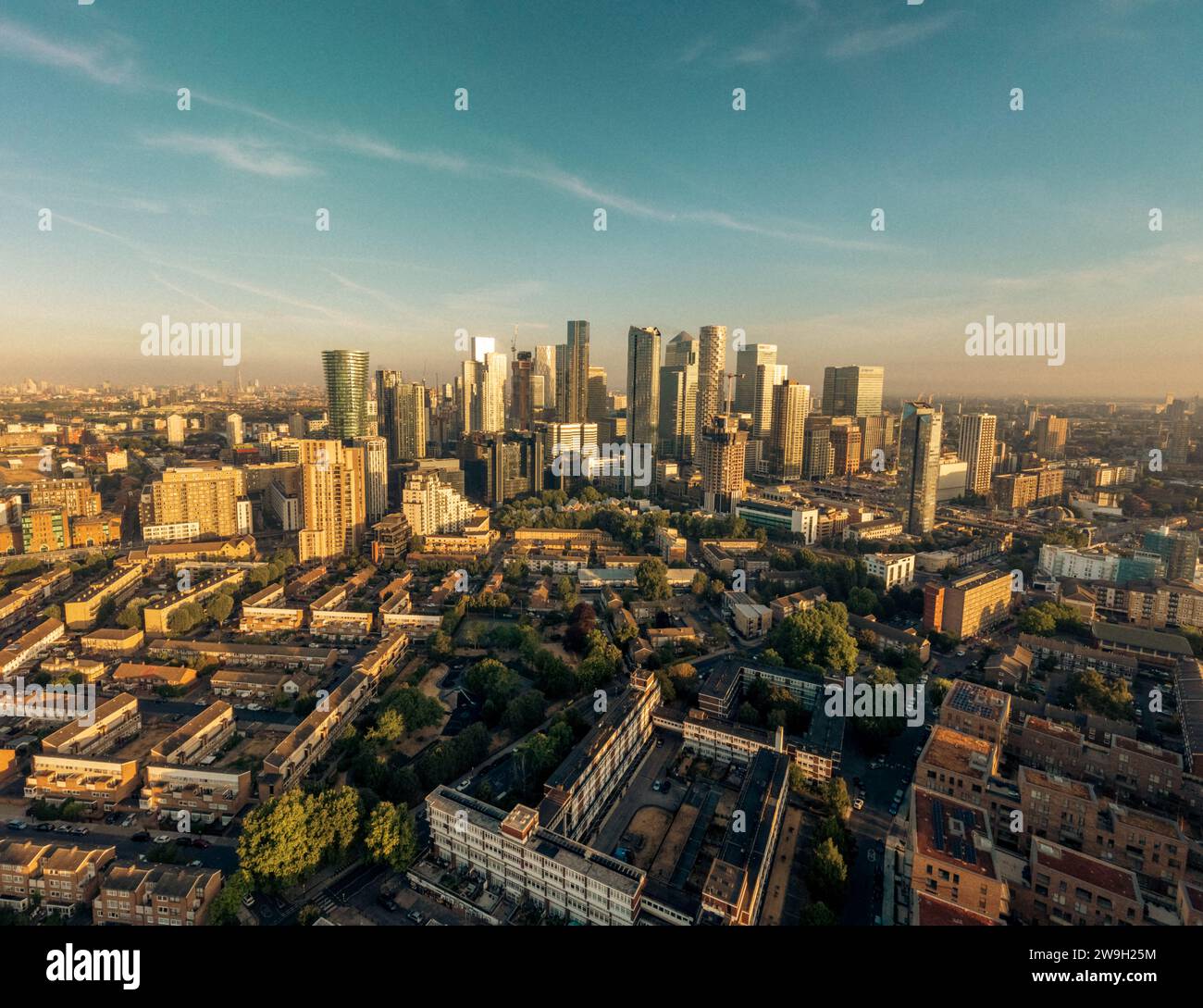 An aerial view of a bustling city skyline illuminated by a warm, orange ...