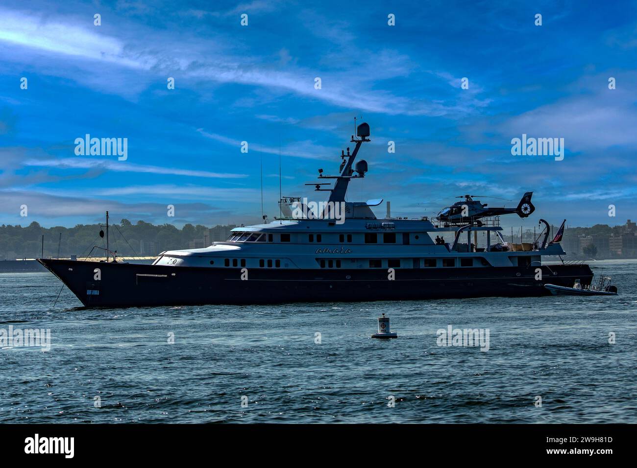 New York, USA; June 1, 2023: Luxury yacht with a helicopter on its helipad, docked in New York City harbor. Stock Photo