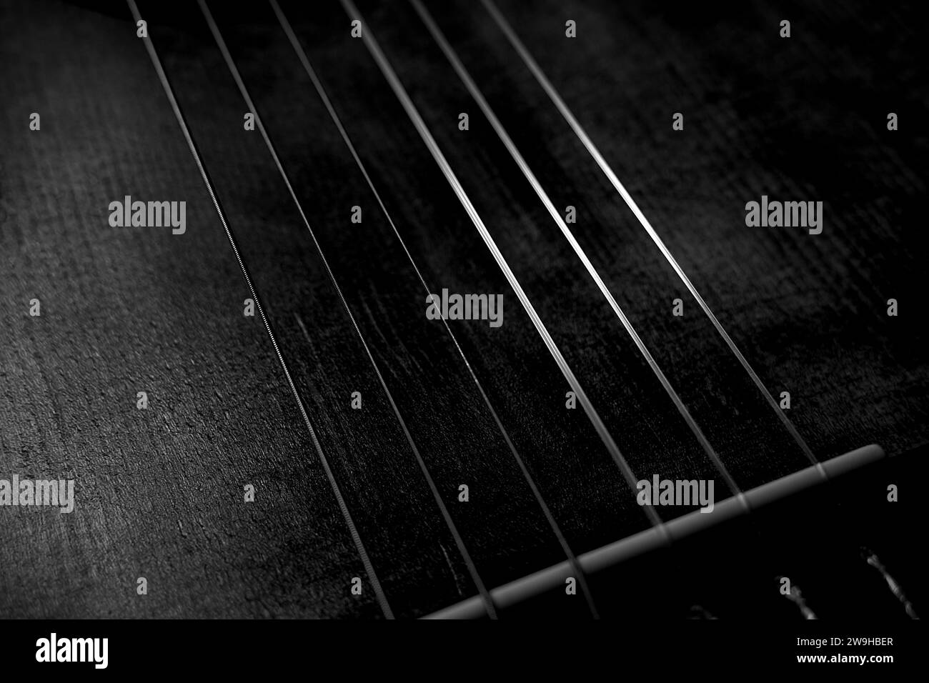 Close Up of Old Classical Guitar Strings and Bridge in Black and White Shadows Light Abstract Stock Photo